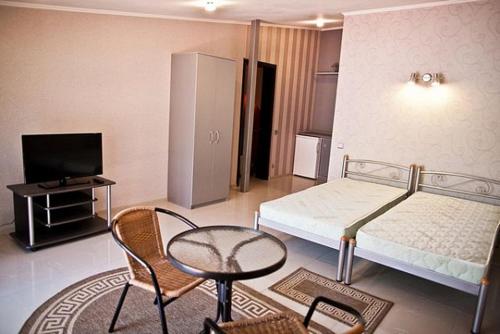 a bedroom with a bed and a table and a chair at Privat Kharkov in Kharkiv