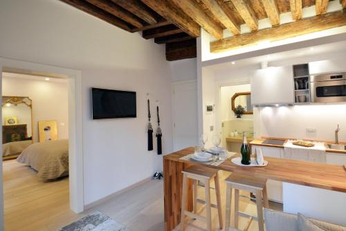 a kitchen and living room with a table and a room with a bed at Home Venice Apartments - Biennale 1 - 2 - 3 in Venice