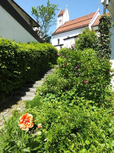 a garden with flowers and a building in the background at Gästehaus Sankt Ulrich in Füssen