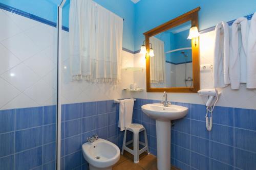 a blue tiled bathroom with a sink and a toilet at Casa Rural La Cambreta in Crevillente
