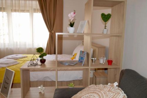 a room with a bed and a book shelf and a desk at Joy City Stay Prefectura 1 in Timişoara