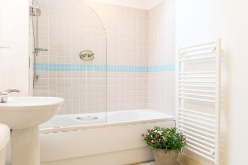 a bathroom with a tub and a sink and a toilet at Beach View, Waterside Cottages in Alnmouth