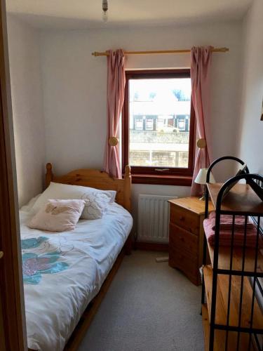 a small bedroom with a bed and a window at 3 Marina Quay in Lossiemouth