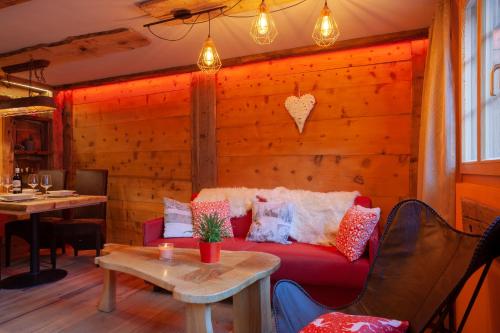 a living room with a red couch against a wooden wall at Chalet Schuler in Zermatt
