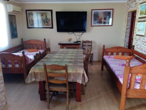 a dining room with a table and chairs and a television at Apartment "Mislav" in Gornji Karin