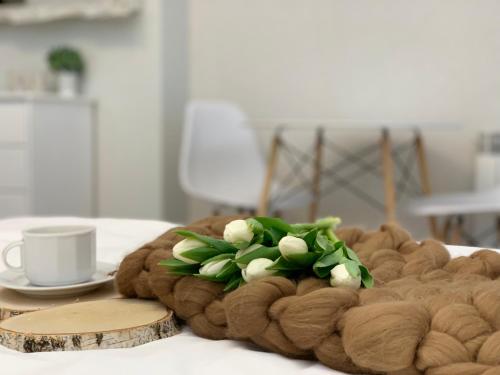 a coffee cup and a plate with a bouquet of flowers at Willa Beskidzka in Myślenice