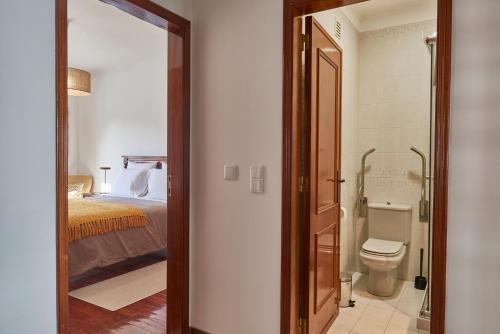 a bathroom with a bed and a toilet in a room at Cascais Handsome Apartment in Cascais