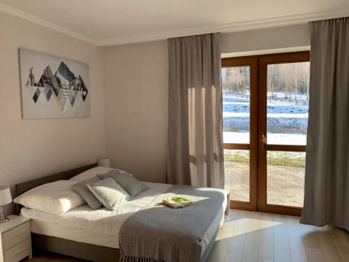 a bedroom with a bed and a sliding glass door at Willa Beskidzka in Myślenice