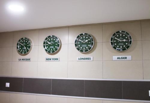 a wall with four clocks on a wall at RESIDENCE TOURISTIQUE DU PORT in Alger