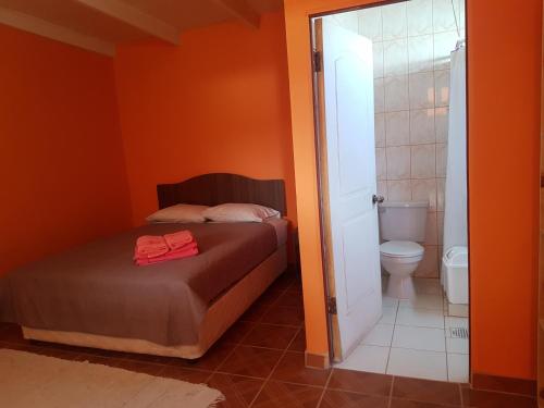 Dormitorio pequeño con cama y aseo en Hostal Casa Colque, en San Pedro de Atacama