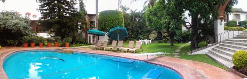 a swimming pool in front of a house at Hotel Vista Hermosa in Cuernavaca
