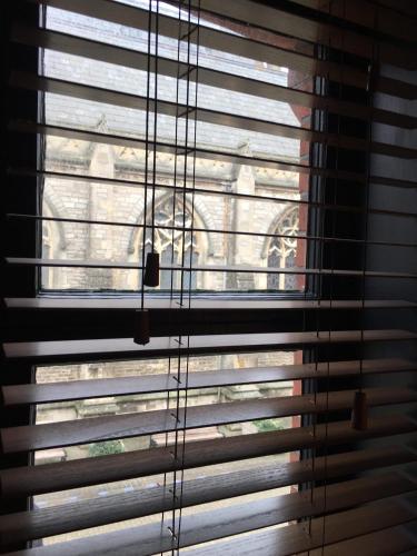 a window with blinds on it with a cat looking out at Charter House in Newport