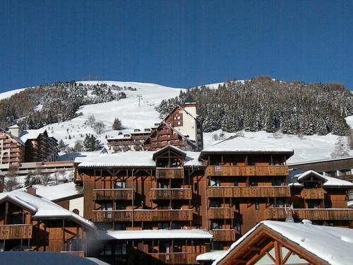 a ski lodge with snow on the roofs of buildings at Au Coeur De La Station in Les Deux Alpes