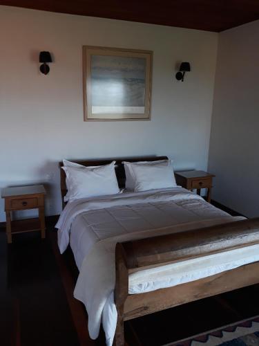a bedroom with a large bed with white sheets and pillows at Pousada Buieié in Lavras Novas