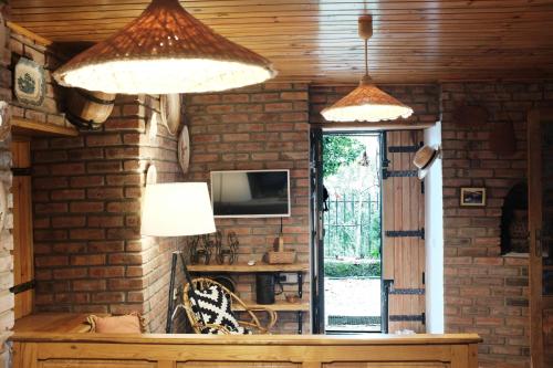 a room with two lamps and a tv and a table at Casa do Penedo Gerês in Terras de Bouro