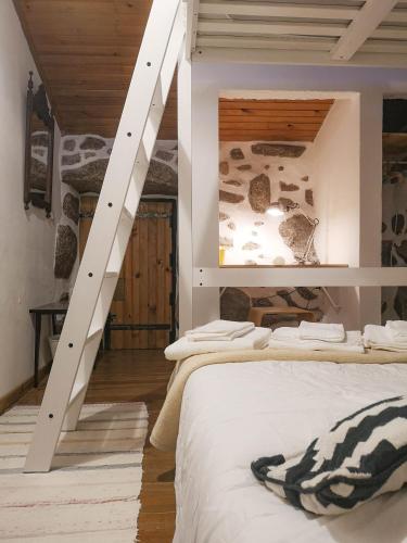 a bedroom with two beds and a staircase at Casa do Penedo Gerês in Terras de Bouro