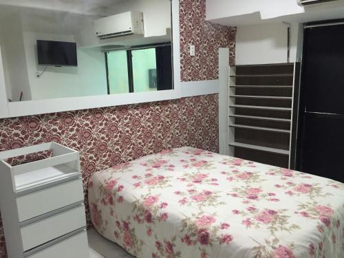 1 dormitorio con 1 cama con pared con motivos florales en Loft Morada do Porto, en Salvador