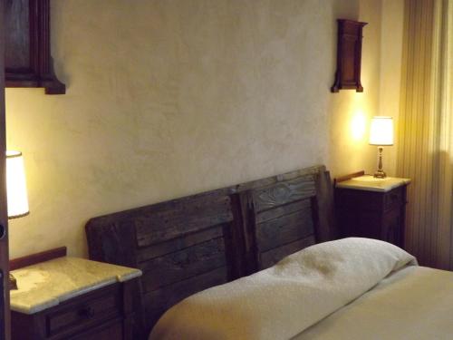 a bedroom with a bed and two night stands and lamps at Casa della Fornace in San Vito al Torre