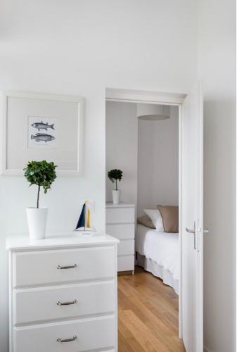 - une chambre avec une commode blanche et un lit dans l'établissement Appartement Bien-être 2 chambres au coeur de Cabourg -, à Cabourg