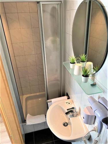 a bathroom with a sink and a shower at Hotel zum Adler in Bad Homburg vor der Höhe