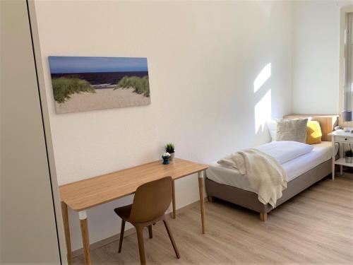 a bedroom with a bed and a desk and a bed and a table at Hotel zum Adler in Bad Homburg vor der Höhe