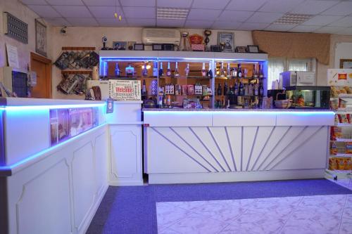 een kamer met een bar met blauwe verlichting in een winkel bij Hotel Stefany in Lago Patria