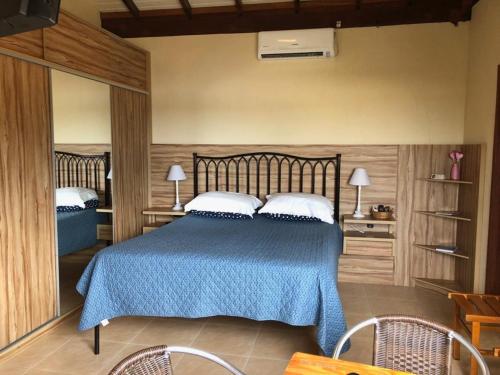 a bedroom with a blue bed with two pillows at Floripa Guest House in Florianópolis
