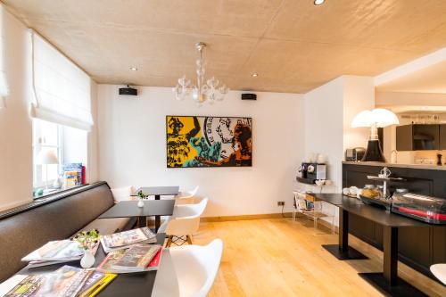 a dining room with black tables and white chairs at La Pipistrelle Hotel in Luxembourg