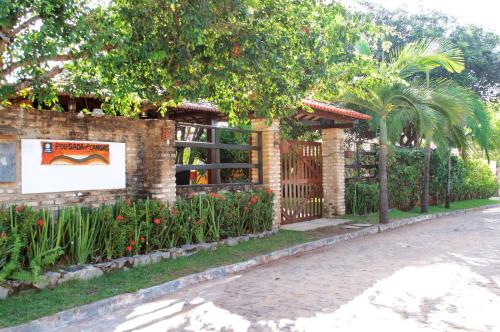 a garden with a fence and a gate and flowers at Eurosol Pousada das Canoas in Pipa