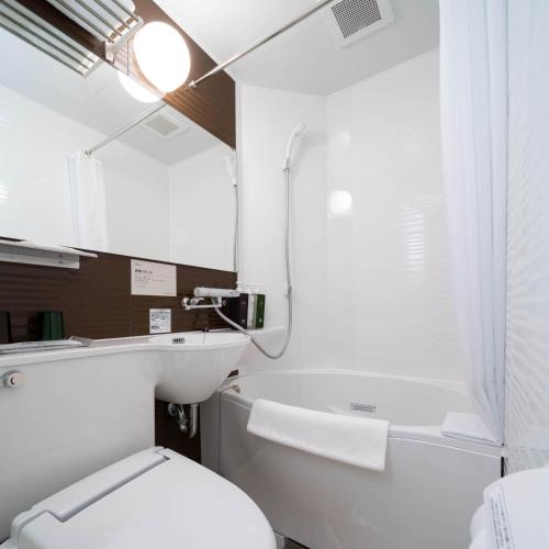 a bathroom with a white toilet and a sink at Super Hotel Premier Ginza in Tokyo