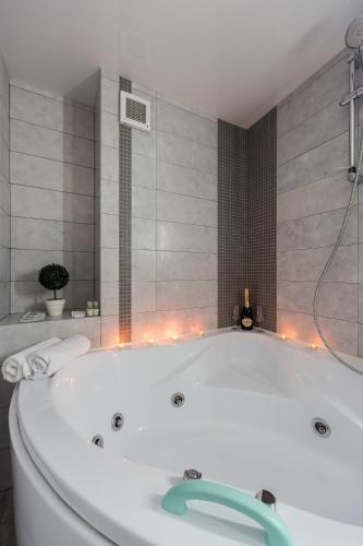 a white bath tub in a bathroom with lights at Langery Residence Central Apartments in Odesa