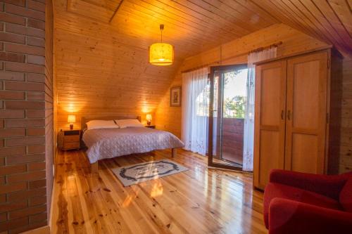 a bedroom with a bed in a room with wooden floors at Komfortowe Domki na Roztoczu- Domek Majdan in Majdan Sopocki