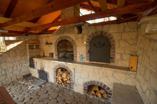 a stone kitchen with a large stone fireplace at Komfortowe Domki na Roztoczu- Domek Majdan in Majdan Sopocki
