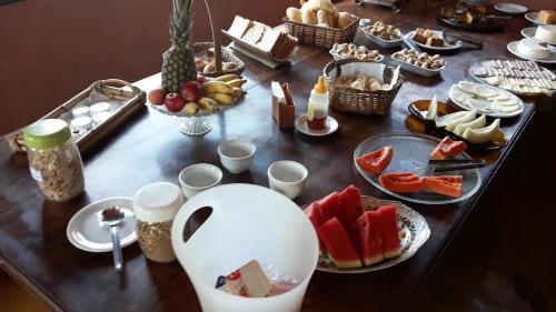 een tafel met borden met voedsel en fruit bij Pousada Buieié in Lavras Novas
