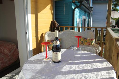 - deux bouteilles de vin assises sur une table sur une terrasse couverte dans l'établissement Bonheur partagé, à Lévis