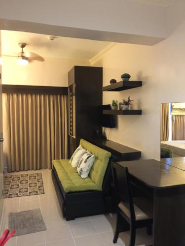 een woonkamer met een groene bank en een tafel bij Studio Unit Cityland Prime Residence in Tagaytay