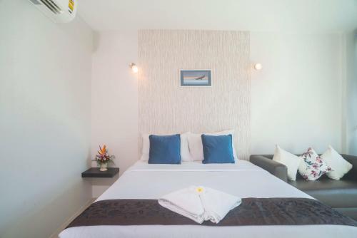 a bedroom with a large white bed with blue pillows at The Tree Samui in Bophut 
