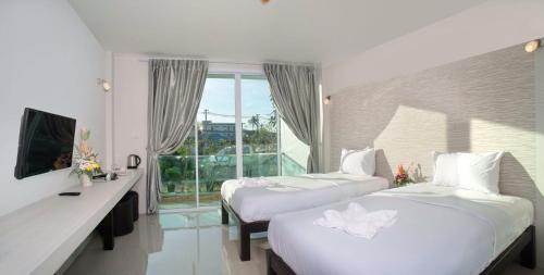 a hotel room with two beds and a window at The Tree Samui in Bophut 