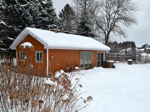 a small house with snow on top of it at Les 4 chalets - Le 605 in Lac-Saint-Paul