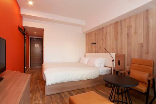 a bedroom with a bed and a table and a tv at Sakura Terrace The Gallery in Kyoto