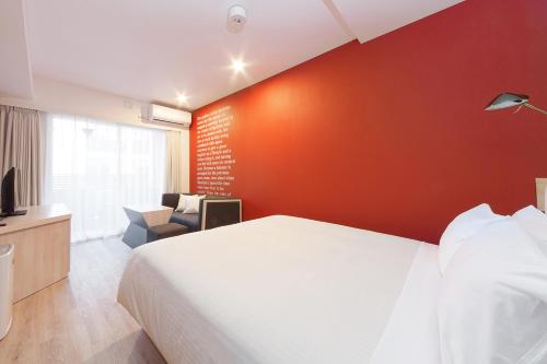 a bedroom with a white bed and a red wall at Sakura Terrace The Gallery in Kyoto