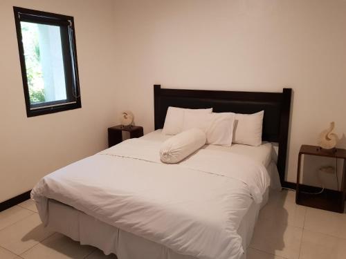 - une chambre dotée d'un grand lit avec des draps et des oreillers blancs dans l'établissement Villa Horizon Nusa Dua, à Nusa Dua