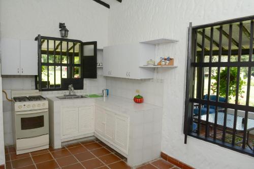 a white kitchen with a stove and a sink at Casa Finca Corales Llano Grande 2 in Rionegro