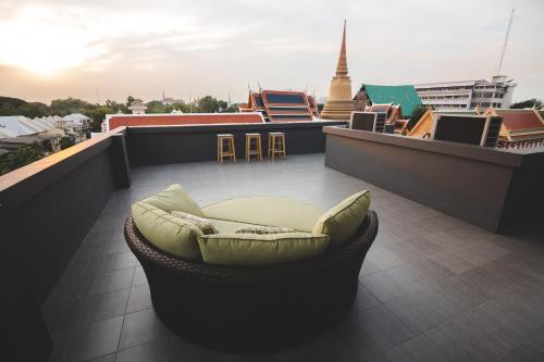 a balcony with a dog bed on a roof at Issara by D Hostel in Bangkok
