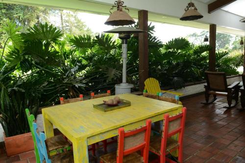 a yellow table and chairs in a room with plants at Casa Finca El Embrujo in Rionegro