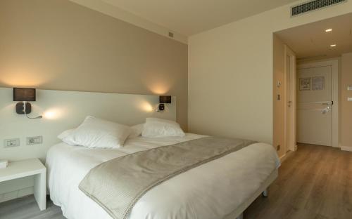 a bedroom with a large white bed with two pillows at La Dolce Vita Hotel in Menton