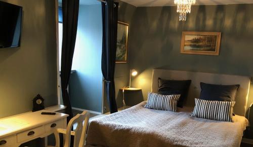 a bedroom with a bed with two pillows and a desk at Brunsbo G:a Biskopsgård Hotell & Konferens in Skara