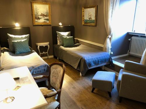 a room with two beds and a table and chairs at Brunsbo G:a Biskopsgård Hotell & Konferens in Skara
