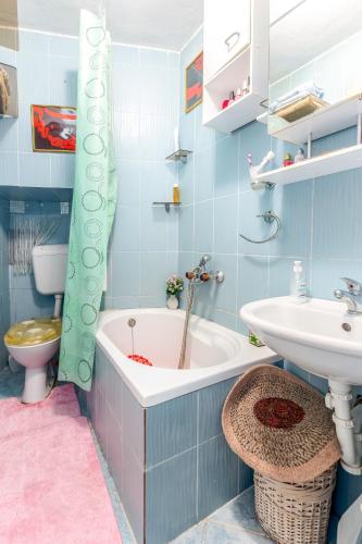 a bathroom with a tub and a sink and a toilet at Studio-apartman Dejan in Bakar
