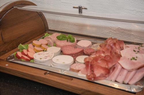 a tray of different types of meats and vegetables at Kurhotel Eichinger in Bad Wörishofen